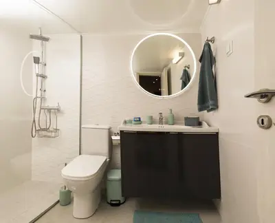 a bathroom with a toilet and a sink and a mirror at Simpli-city home in Piraeus