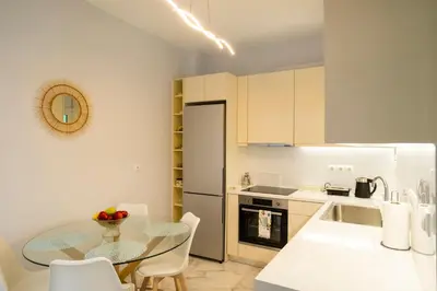 a kitchen with a table and a kitchen with white cabinets at Simpli-city home in Piraeus