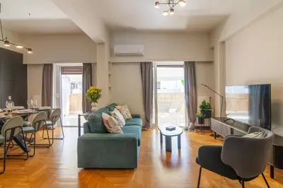 a living room with a green couch and a table at A38 Brand new lux 3BD in Koukaki with big terrace in Athens