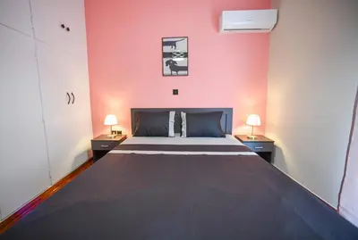 a bedroom with a large bed and two lamps at Spacious Apartment near Panormou Metro with Self Check-in in Athens