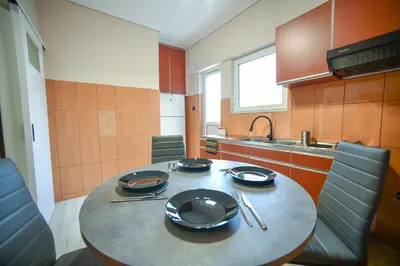 a kitchen with a table with plates and utensils on it at Spacious Apartment near Panormou Metro with Self Check-in in Athens