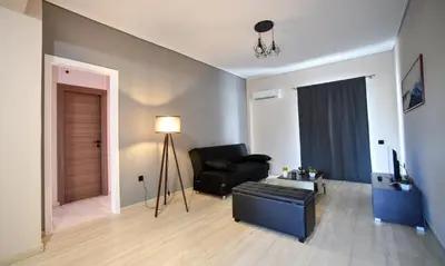 a living room with a black chair and a couch at Spacious Apartment near Panormou Metro with Self Check-in in Athens