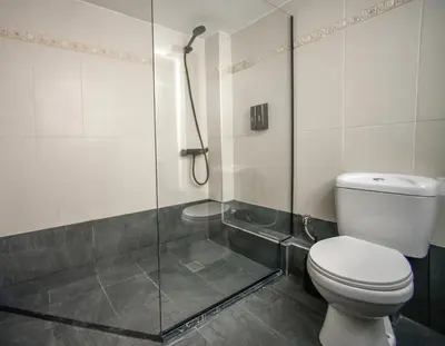 a bathroom with a toilet and a glass shower at Spacious Apartment near Panormou Metro with Self Check-in in Athens
