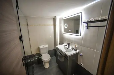 a bathroom with a toilet and a sink and a mirror at Spacious Apartment near Panormou Metro with Self Check-in in Athens