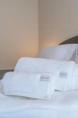 two white towels sitting on top of a bed at Voula Riviera Luxury Apartment in Athens