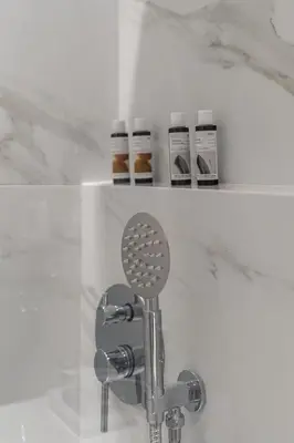 a shower with a mixer and two bottles of honey at Voula Riviera Luxury Apartment in Athens