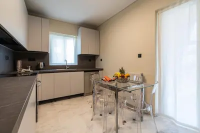 a kitchen with a glass table and a counter top at Voula Riviera Luxury Apartment in Athens