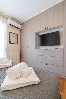 a bedroom with two beds and a flat screen tv at Voula Riviera Luxury Apartment in Athens