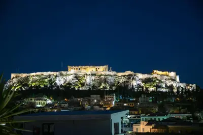 a castle on top of a mountain at night at Urban loft with balcony across the Acropolis! in Athens