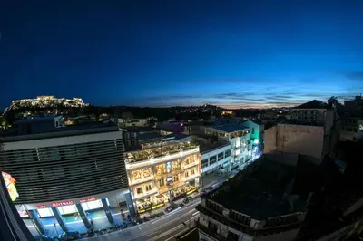 a view of a city at night at Urban loft with balcony across the Acropolis! in Athens