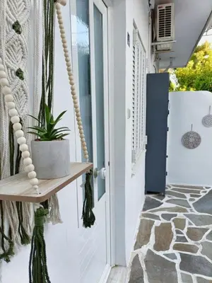 a porch with a swing and a plant at Harmony Apartment Near Metro Station in Athens