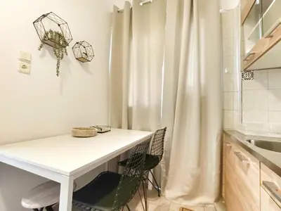 a kitchen with a white table and a curtain at Harmony Apartment Near Metro Station in Athens