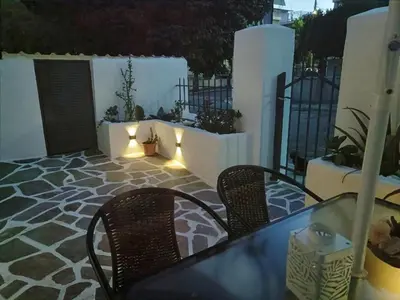 a table and chairs on a patio with lights at Harmony Apartment Near Metro Station in Athens