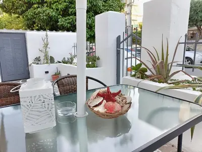 a glass table with a bowl of food on a balcony at Harmony Apartment Near Metro Station in Athens