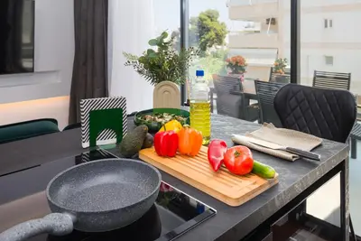 a table with a cutting board with vegetables on it at Emerald Stone Apartment Varkiza in Vari