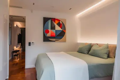 a bedroom with a bed and a painting on the wall at Emerald Stone Apartment Varkiza in Vari
