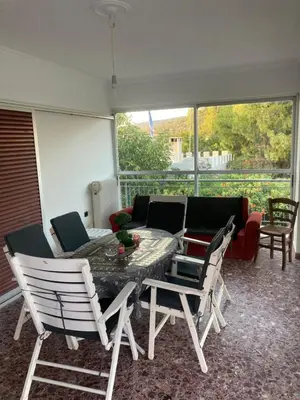a patio with a table and chairs and a couch at Billy & Andrianna Villa Lagonisi in Kalívia Thorikoú