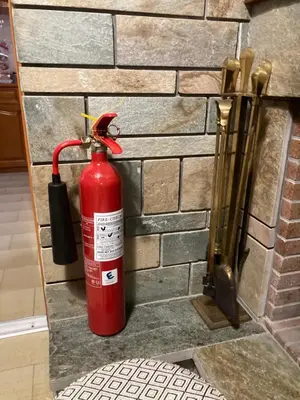 a fire extinguisher on the side of a brick wall at Billy & Andrianna Villa Lagonisi in Kalívia Thorikoú