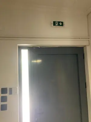 a exit sign above a door in a room at Billy & Andrianna Villa Lagonisi in Kalívia Thorikoú