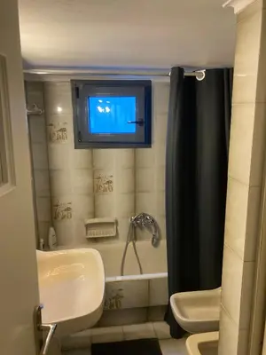 a bathroom with a sink and a tv on the wall at Billy & Andrianna Villa Lagonisi in Kalívia Thorikoú