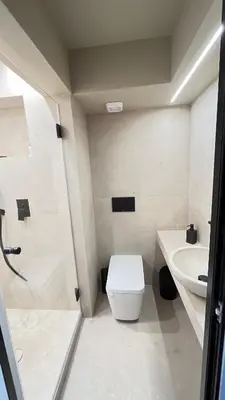 a white bathroom with a toilet and a sink at Luxury Haven in Saronida