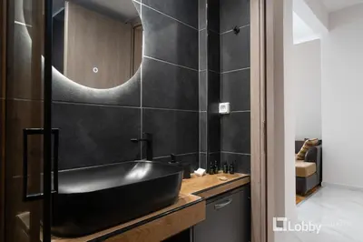 a bathroom with a black sink and a mirror at Aria Apartment in Athens