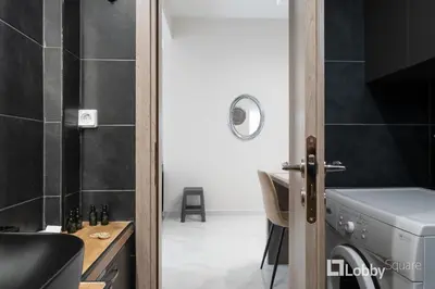 a bathroom with a washer and dryer in a room at Aria Apartment in Athens