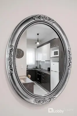 a large silver mirror hanging on a wall in a kitchen at Aria Apartment in Athens