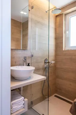 a bathroom with a sink and a glass shower at RoofTop Sea View Cabin in Vari