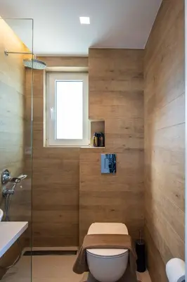 a bathroom with a toilet and a window at RoofTop Sea View Cabin in Vari