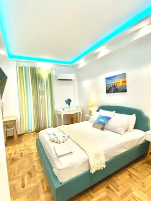 a bedroom with a large bed with a blue ceiling at Soul spa suites in Athens