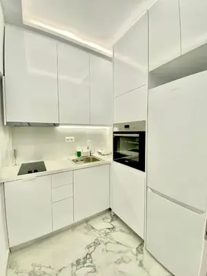 a white kitchen with marble floors and white cabinets at Soul spa suites in Athens