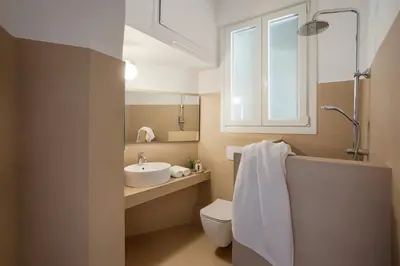 a bathroom with a sink and a toilet and a window at Hospes - Chic retro retreat in the heart of Athens in Athens