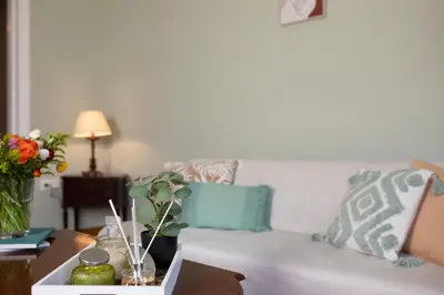 a living room with a white couch and a table at Hospes - Chic retro retreat in the heart of Athens in Athens