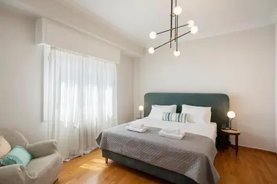 a bedroom with a large bed and a couch at Hospes - Chic retro retreat in the heart of Athens in Athens