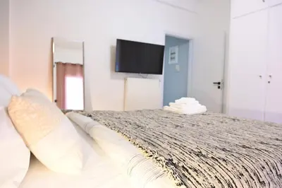 a bedroom with a bed with a tv on the wall at Stylish and spacious apartment in cool area in Athens