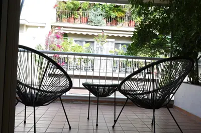 two black chairs sitting on a balcony with a window at Stylish and spacious apartment in cool area in Athens