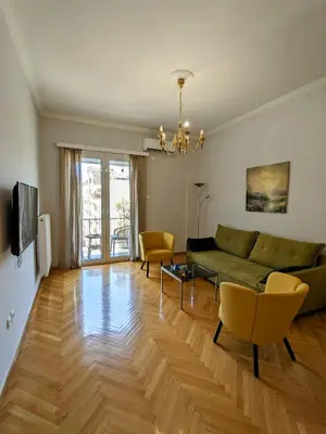 a living room with a green couch and chairs at Athenian Charm, Two-bedroom Flat in Athens