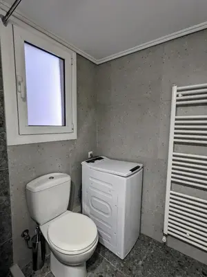 a bathroom with a white toilet and a window at Athenian Charm, Two-bedroom Flat in Athens