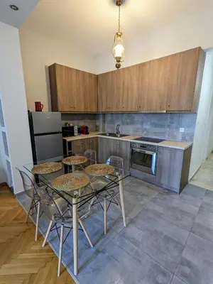 a kitchen with a table and chairs in a kitchen at Athenian Charm, Two-bedroom Flat in Athens