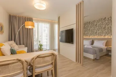a hotel room with a bed and a table and chairs at The Mediterranean Suites in Piraeus