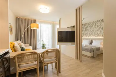 a hotel room with a bed and a table and chairs at The Mediterranean Suites in Piraeus