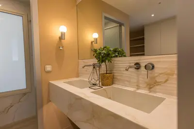 a bathroom with a large sink and a mirror at The Mediterranean Suites in Piraeus