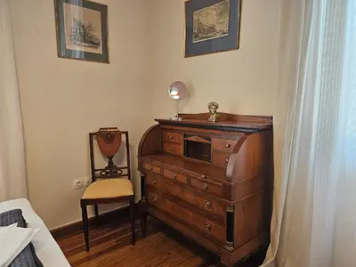 a bedroom with a dresser and a chair next to a bed at Acropolis Eternal Mansion by YHA in Athens