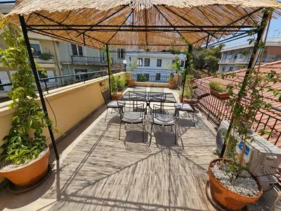 a patio with tables and chairs on a balcony at Acropolis Eternal Mansion by YHA in Athens