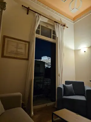 a living room with a couch and a window at Acropolis Eternal Mansion by YHA in Athens