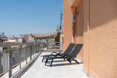 a pair of chairs sitting on the balcony of a building at LIV - Sunny Penthouse Near Acropolis in Athens