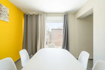 a white table and chairs in a room with a window at LIV - Sunny Penthouse Near Acropolis in Athens