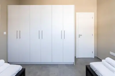 two wardrobes in a bedroom with white cabinets at LIV - Sunny Penthouse Near Acropolis in Athens