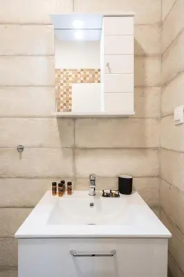 a bathroom with a white sink and a mirror at LIV - Sunny Penthouse Near Acropolis in Athens